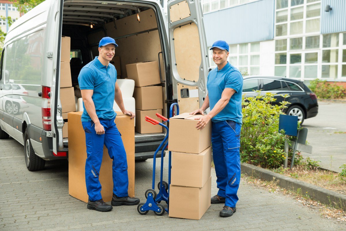 Worker With Cardboard Boxes In Front Of Truck